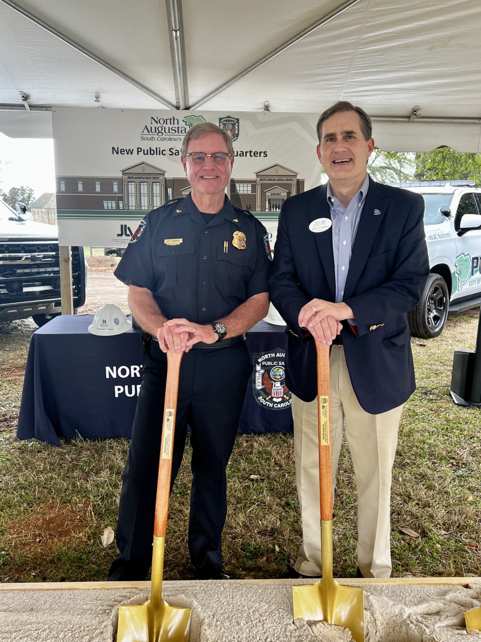 police chief and mayor holding shovels